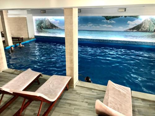 una piscina con 2 sillas en el agua en Apartmani Madera, en Kopaonik