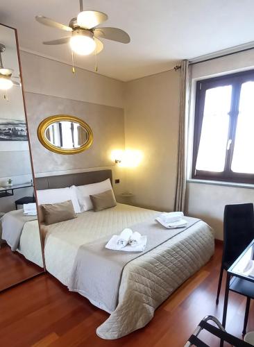 a bedroom with a large bed with a mirror at Villa Laura B&B in Fossano