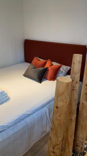 una cama con muchas almohadas encima en The Crush, en Ersfjordbotn