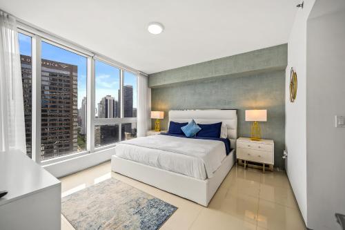 a bedroom with a white bed and large windows at Breathtaking Ocean View Unit Icon Brickell W in Miami