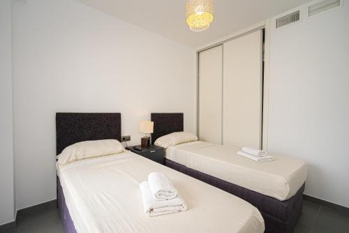 a bedroom with two beds with towels on them at Vistabella in Orihuela Costa