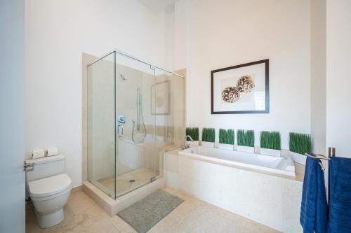 a bathroom with a shower and a toilet and a tub at Breathtaking Ocean View Unit Icon Brickell W in Miami
