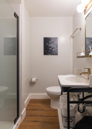 a white bathroom with a toilet and a sink at Hotel Stratford San Francisco - Handwritten Collection in San Francisco
