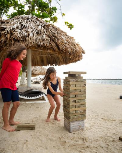 a woman and a little girl playing on the beach at Placencia Resort in Maya Beach
