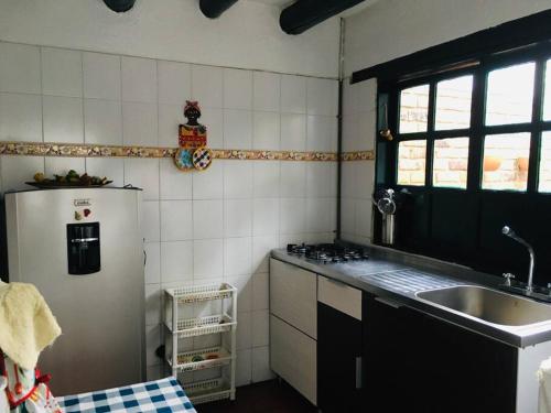 a kitchen with a sink and a refrigerator at Casa Familiar Central Villa Diana in Villa de Leyva