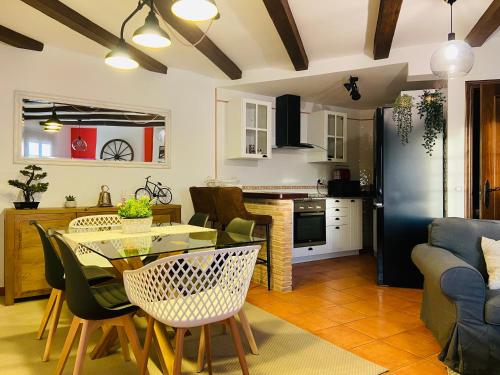 una cucina e un soggiorno con tavolo e sedie di Apartamento Rural La Bandolera a El Bosque