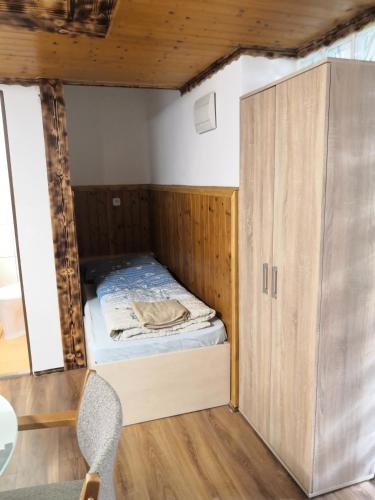 a small room with a bed and a cabinet at Penzion u Šmídů Náměstí in Jaroslavice