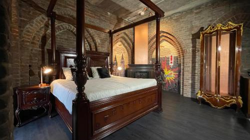 a bedroom with a canopy bed in a brick wall at Walburgis Residenties in Arnhem