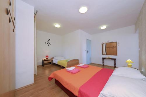 a bedroom with a large bed and a mirror at Apartments Luca in Ražanac