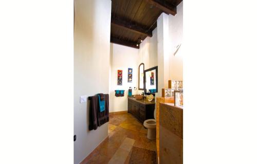 a hallway with a bathroom with a toilet and a television at Vista Hermosa Resort and Spa in Rosarito