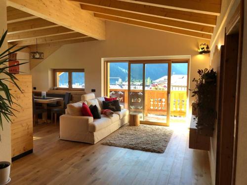 a living room with a white couch and a table at Cèsa Prinoth in Campitello di Fassa