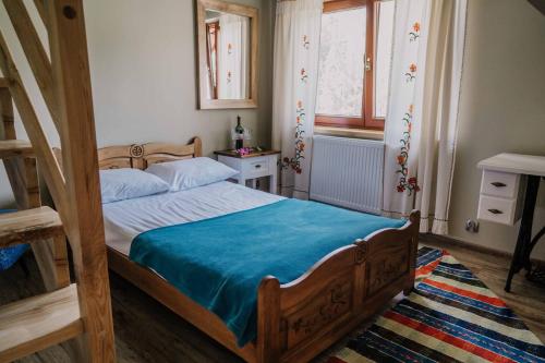 a bedroom with a wooden bed with a blue blanket at Apartament nad Potokiem in Witów