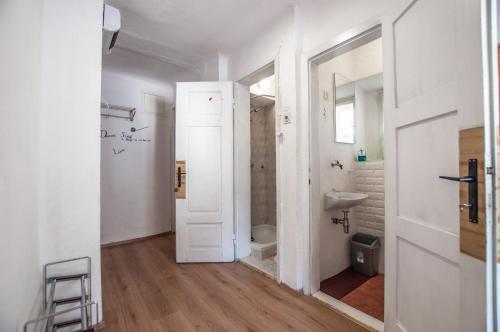 a white bathroom with a toilet and a sink at Hostel, Rooms and Apartment Ceklin in Bohinj