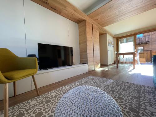 a living room with a flat screen tv and a rug at Chalet Lilla Livigno in Livigno