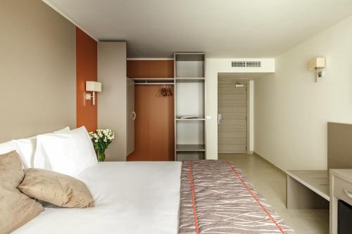 a bedroom with a large white bed and a desk at Mayflower Hotel Malta in St Paul's Bay