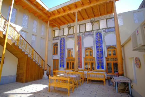 Habitación con mesa y sillas en un edificio en Koh-i-noor, en Bukhara