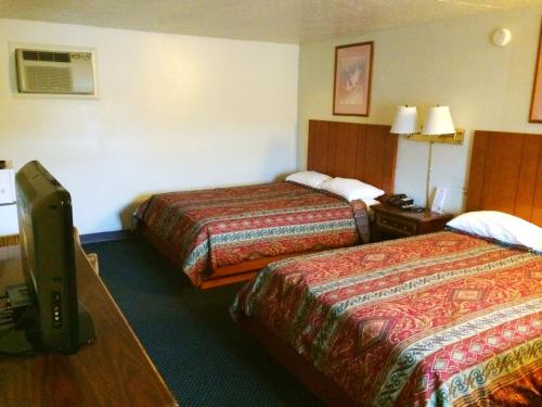 a hotel room with two beds and a television at Motel Edgewood in Edgewood
