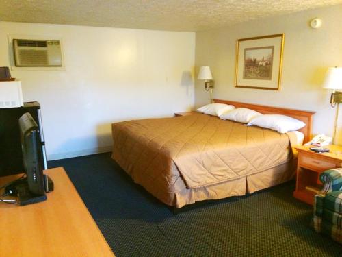 um quarto de hotel com uma cama e uma televisão em Motel Edgewood em Edgewood