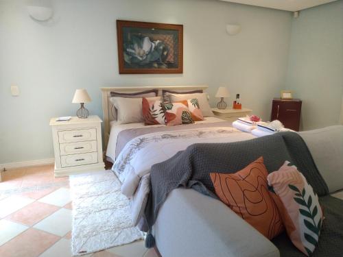 a bedroom with a large bed and a couch at Casa Verde - Suíte 1 in Teresópolis