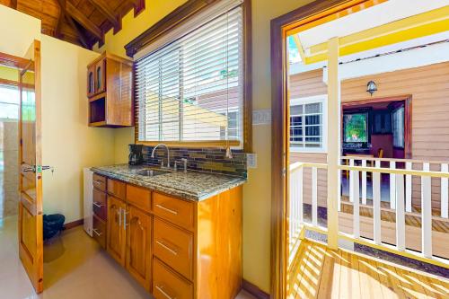 a kitchen with a sink and a large window at FLA at Hummingbird Estate Gold Standard Certified in Dangriga
