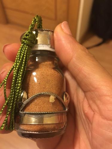 a hand holding a jar with a green string around it at Desert Luxury Tented & Activities in Hassilabied