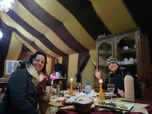 two women sitting at a table in a restaurant at Desert Luxury Tented & Activities in Hassilabied