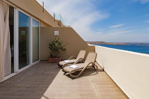 two chairs on a balcony with a view of the ocean at Mayflower Hotel Malta in St Paul's Bay