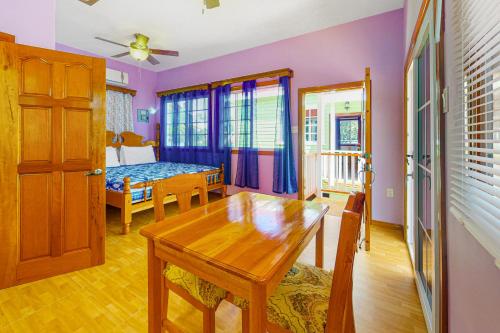 a living room with a table and a bedroom at Bella at Hummingbird Estate Gold Standard Certified in Dangriga
