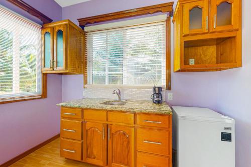 a kitchen with wooden cabinets and a white refrigerator at Bella at Hummingbird Estate Gold Standard Certified in Dangriga