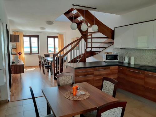 une cuisine et une salle à manger avec une table et un escalier dans l'établissement Apartmán Nesyt, à Sedlec