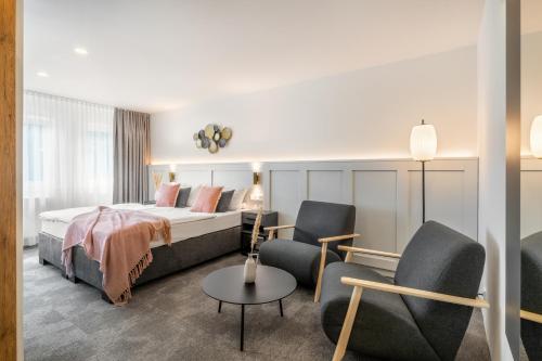 een hotelkamer met een bed en twee stoelen bij Hotel Bad Minden in Minden