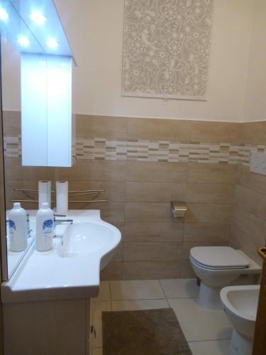 een badkamer met een witte wastafel en een toilet bij Casa via dei platani in Chieti