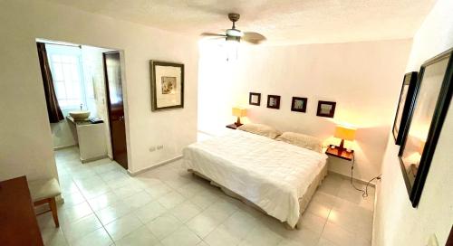 1 dormitorio con 1 cama blanca en una habitación en Cómodo y bello departamento cerca de la Zona hotelera y el ferry en Isla mujeres, en Cancún
