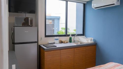 a kitchen with a refrigerator and a sink and a window at Aldeazul by Andiani Travel in Cancún