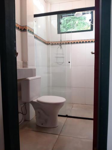 a bathroom with a toilet and a window at Charmoso studio em Tiradentes in Tiradentes