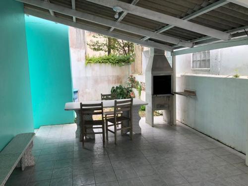an outdoor patio with a table and chairs and an oven at casa praia em bombinhas in Bombinhas