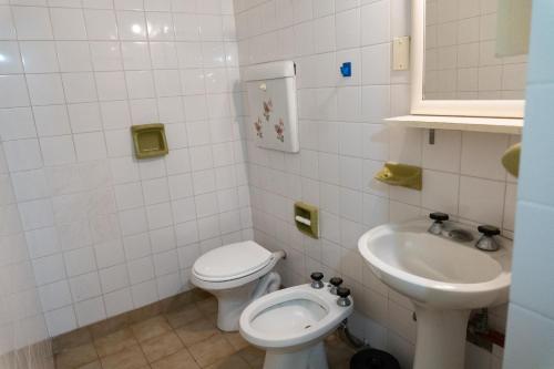 y baño con aseo y lavamanos. en Alfil Apartamentos Villa Gesell en Villa Gesell