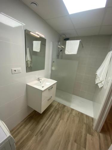 a white bathroom with a sink and a mirror at Cozy flat in La Petxina B in Valencia