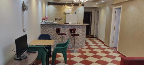 a room with a kitchen with a counter and chairs at 2bedroom apartment in Summer Land Beach Resort in Hurghada
