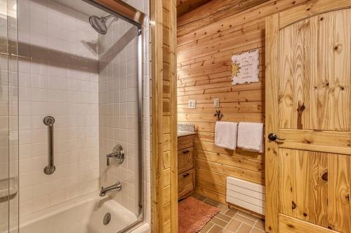 a wooden bathroom with a shower and a tub at Sonshine By The Stream, Next To A Stream, 560 FREE tickets each paid day in Cosby