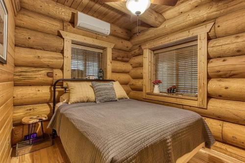a bedroom with a bed in a log cabin at Sonshine By The Stream, Next To A Stream, 560 FREE tickets each paid day in Cosby
