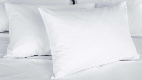 a stack of white pillows on a bed at Will Rogers Inn in Claremore