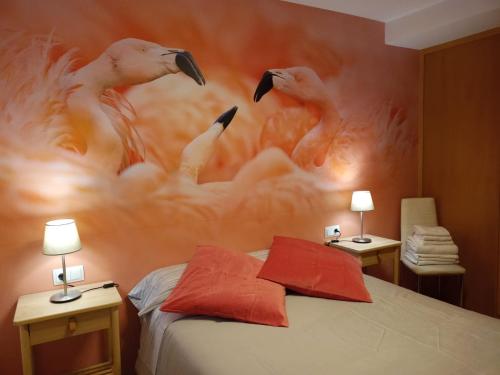 a bedroom with a painting of flamingos on the wall at Apartamento Alcázar parking incluido VU-TERUEL-18-035 in Teruel