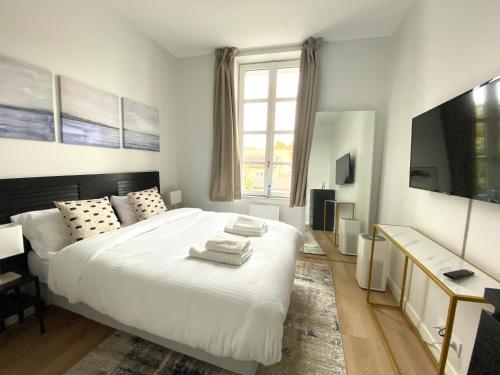 een slaapkamer met een wit bed en handdoeken bij ModernAppart Marmande Centre in Marmande