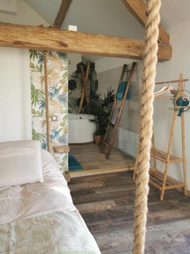 - une chambre avec un lit doté d'une corde suspendue au plafond dans l'établissement La bulle suspendue, à Bassevelle