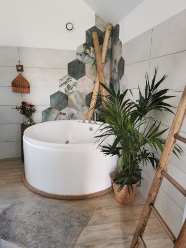 La salle de bains est pourvue d'une baignoire et de plantes. dans l'établissement La bulle suspendue, à Bassevelle