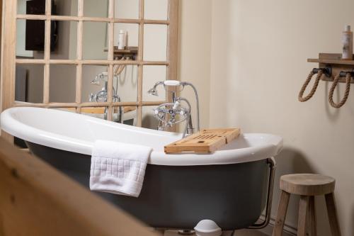 a bath tub with a wooden tray on it in a bathroom at Castle Inn in Lydford