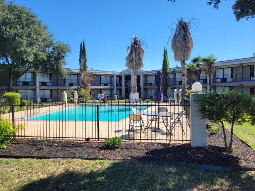 una valla con piscina frente a un edificio en Knights Inn San Antonio near Frost Bank Center, en San Antonio