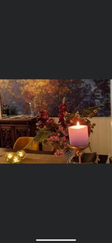 a candle sitting on top of a table with flowers at Villa Rozenhof in Almen