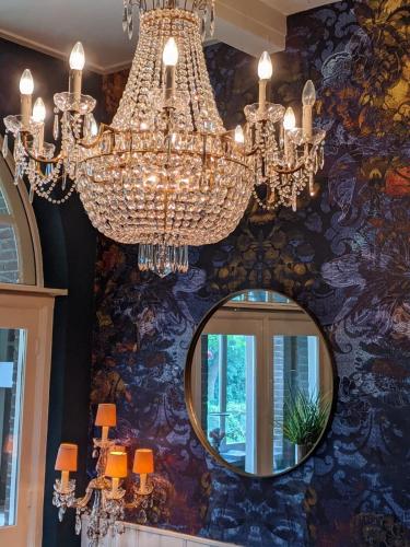 a chandelier hanging from a wall with a mirror at Villa Rozenhof in Almen